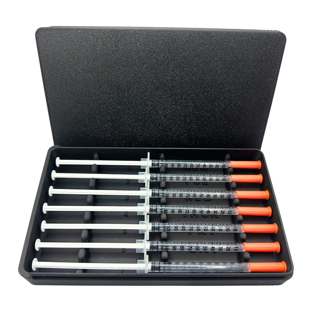 7-slot prefilled syringe case in black loaded with seven 1ml insulin syringes. Weekly organizer with numbered slots and day-of-week labels Monday through Sunday. Sliding lid syringe holder keeps prefilled doses separated and protected. Compact storage case for daily dosing routines, fridge organization, or travel.