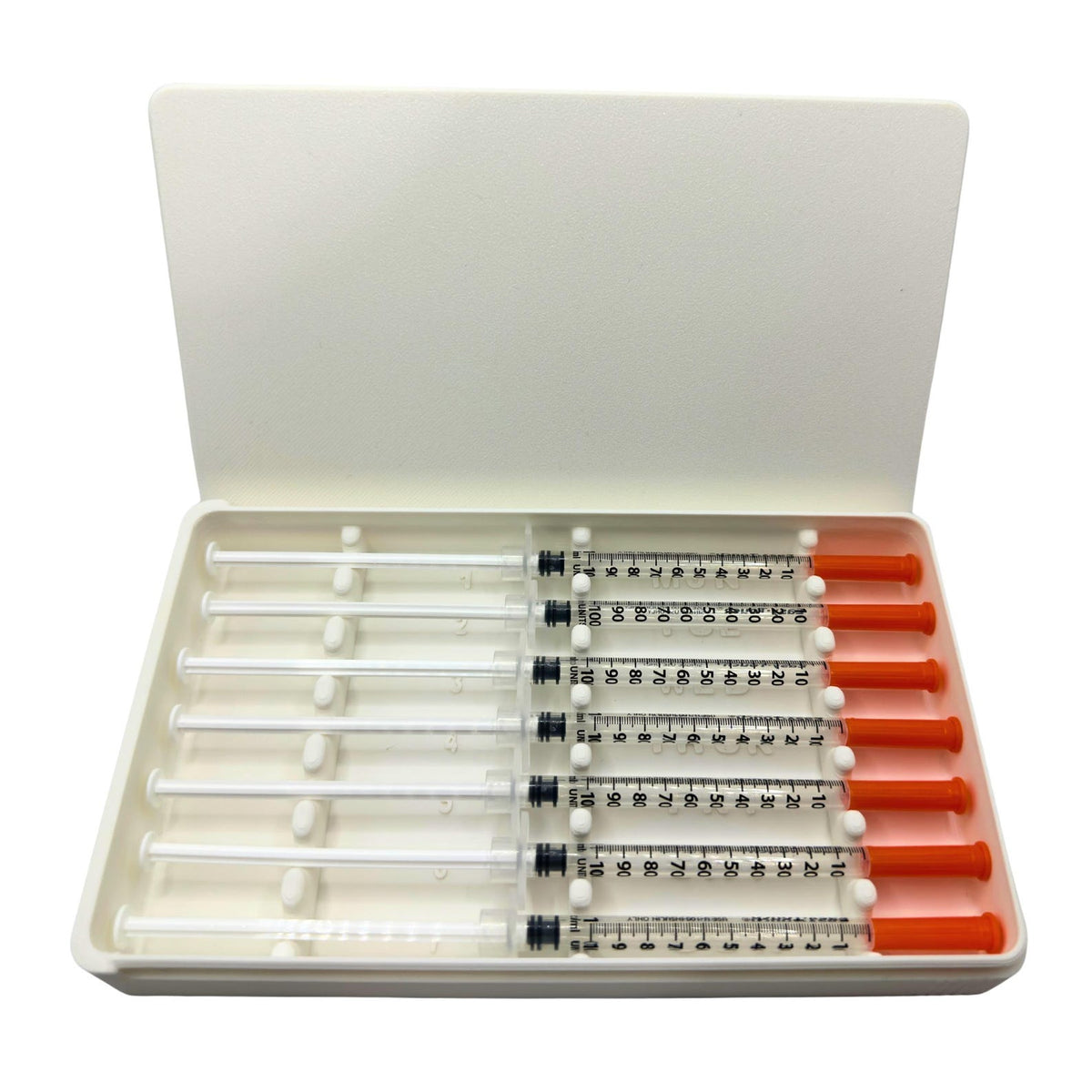 White 7-slot prefilled syringe case open with seven 1ml insulin syringes loaded. Weekly syringe organizer with numbered slots and day-of-week labels Monday through Sunday. Sliding lid syringe holder keeps prefilled doses separated and protected. Compact storage case for insulin, TRT, GLP-1 daily dosing routines.