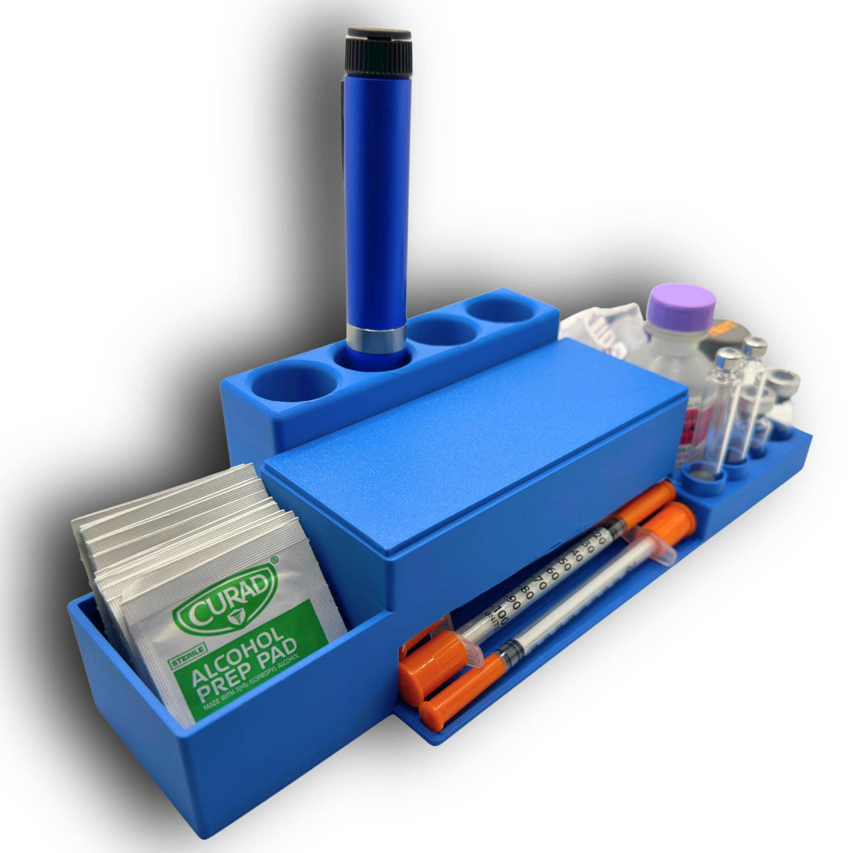Opposite angle of the blue injection supply organizer showing the alcohol prep pad compartment, rear pen holder and syringe access tray.