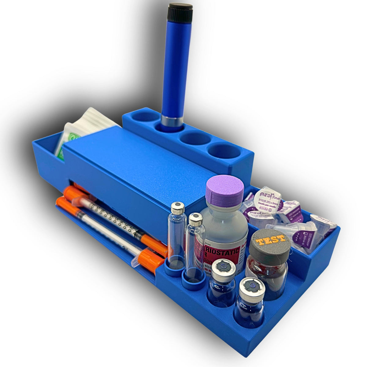 Angled view of the desktop syringe organizer showing vial and cartridge holders, pen needle compartment, lidded dispenser and an upright injection pen.