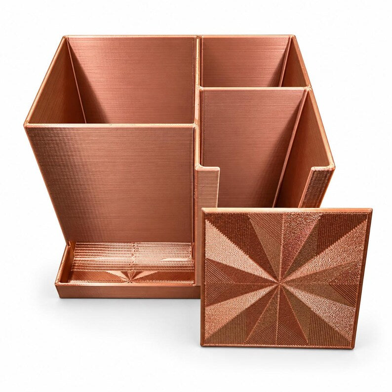 Copper desktop injection organizer with empty needle, pen and alcohol wipe compartments and its geometric lid displayed in front.
