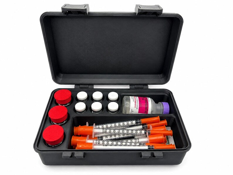 Open black vial storage case holding three red-capped 10ml vials, six white-capped 3ml vials, syringes and a larger bottle, with a hinged lid and two snap latches.