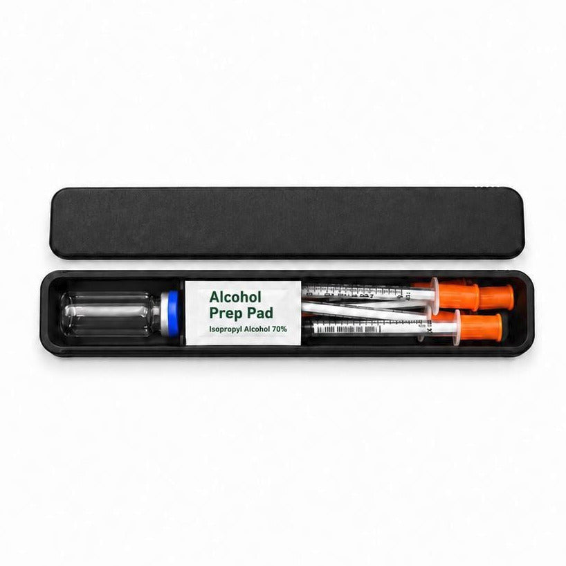 Open black slim TRT travel case on white, with its slide-off lid above, a blue-capped vial, an Alcohol Prep Pad packet and orange-capped syringes. Demonstration supplies are not included.
